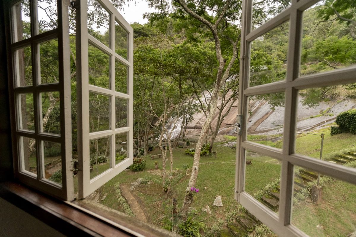 Janela da cozinha aberta para a cachoeira e o Deck